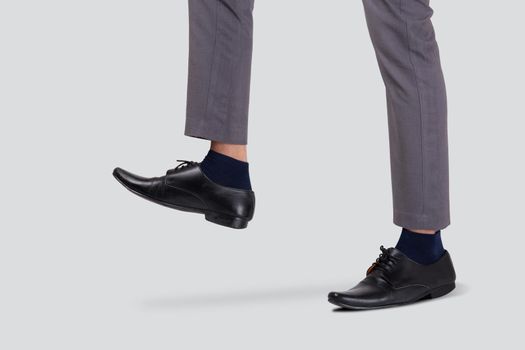 Foot of businessman walking for achievement isolated on white background, leg of leadership moving progress, metaphor and conceptual, copy space, cut out, man standing, business concept.