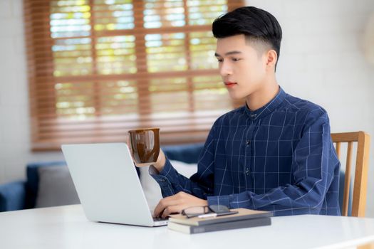Young business man working from home with laptop computer on desk, freelance male sitting stay home using notebook for communication and relax on table, entrepreneur in startup business, new normal.