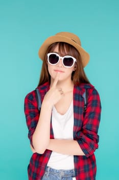 Beautiful portrait young asian woman wear sunglasses and hat having backpack smile confident enjoy summer holiday isolated blue background, tourist model girl thinking idea planning travel concept.