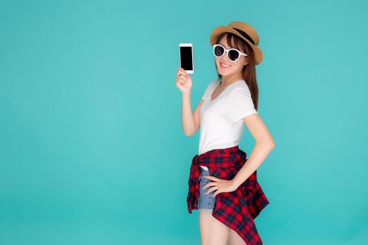 Beautiful young asian woman showing smart mobile phone for presenting something in travel summer trip in vacation isolated on blue background, asia girl holding smartphone, holiday concept.