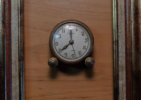 Vintage clock on a wooden background and in a frame