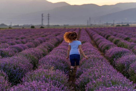 Happy Young Woman Enjoying Life in Lavender Field at Sunset. 