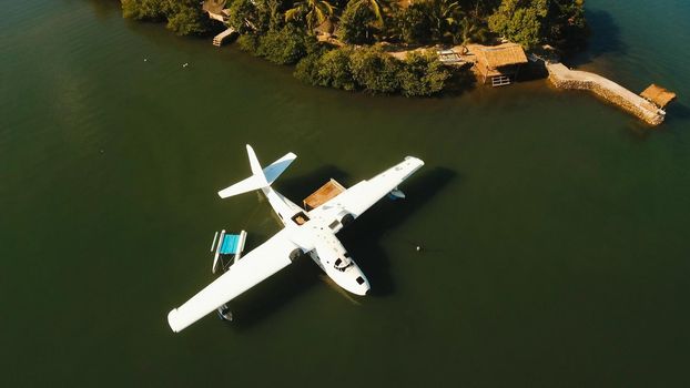 Aerial view: White Seaplane parked in the sea bay of the tropical island. Hydroplane in the lagoon and coastline. Philippines,Palawan, Busuanga. Travel concept