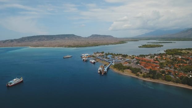 Aerial view ferry port Gilimanuk with ferry boats, vehicles and infrastructure, Bali,Indonesia. Ferries for transport vehicles and passengers in the port. Port for departure from Bali to the island of Java. Travel concept.