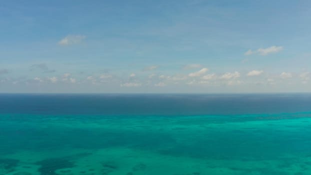 Flying over the sea with turquoise water, atoll and coral reef, aerial view. Balabac, Palawan, Philippines. Summer and travel vacation concept.