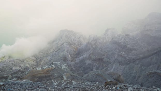 Extraction of sulfur in the crater of a volcano. Sulfur gas, smoke. Kawah Ijen, crater with acidic crater lake where sulfur is mined. Ijen volcano complex is a group of stratovolcanoes in the Banyuwangi Regency of East Java, Indonesia.