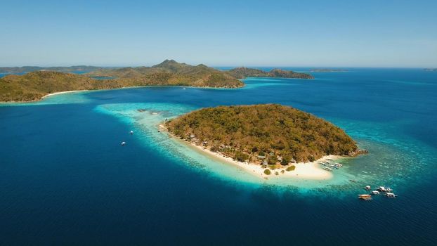 Aerial view of tropical beach on the island Banana, Philippines. Beautiful tropical island with sand beach, palm trees. Tropical landscape: beach with palm trees. Seascape: Ocean, sky, sea. Travel concept.