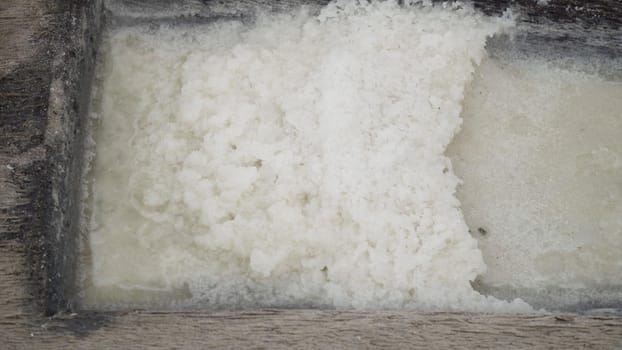 Production of sea salt in the Bali,Indonesia. Salt crystallizes out of the ground in salt farm, filled with natural salt from the sea.