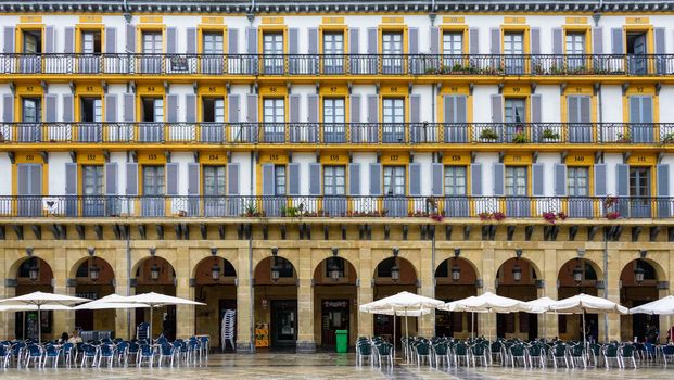 SAN SEBASTIAN, SPAIN - CIRCA SEPTEMBER 2013: Building facade, arcades and cafe terrace on Plaza de la Constitucion