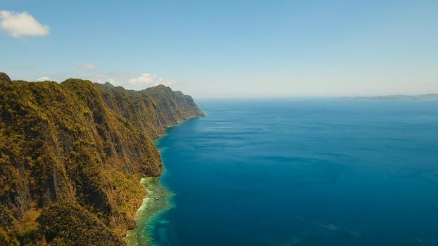 Aerial view: Lagoon with blue, azure water in the middle of small islands and rocks. Beach, tropical island, sea bay and lagoon, mountains with forest, Palawan, Coron. Busuanga. Seascape, tropical landscape. Philippines. Travel concept