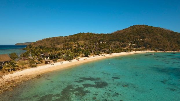 Aerial view of tropical beach with beach,resort, hotels. Philippines. Beautiful tropical island with sand beach, palm trees. Tropical landscape: beach with palm trees. Seascape: Ocean, sea. Travel concept.