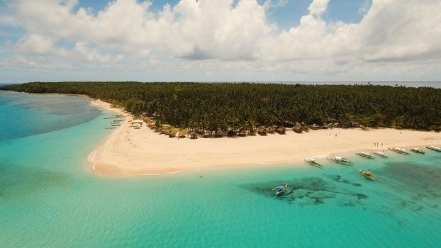 Aerial view of beautiful tropical island Daco with white sand beach. View of a nice tropical beach from the air. Beautiful sky, sea, resort. Seascape: Ocean and beautiful beach paradise. Philippines. Travel concept.