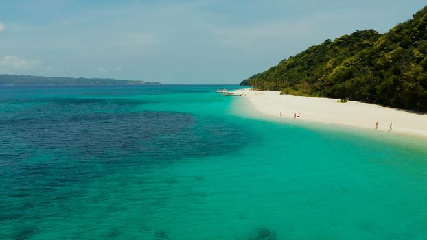 Sandy tropical beach with tourists and blue clear sea. Summer and travel vacation concept. Boracay, Philippines. Seascape with beach on tropical island. Puka shell beach