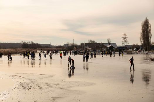 Schipluiden,Holland,14-feb-2021:people skating on the canal on the frozen lake, it has been years ago that is was so cold in Holland, people can skate