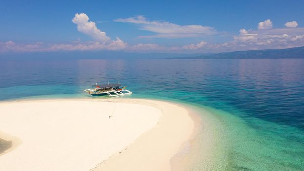 Perfect beach with blue water and white sand. Boat off the coast of a tropical island. Summer and travel vacation concept. Digyo Island, Philippines. Holiday and vacation concept.
