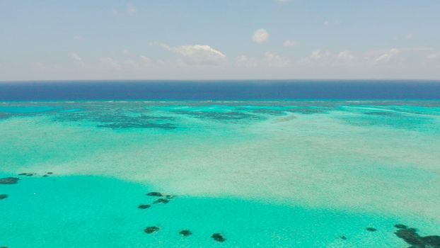 Tropical coral atoll with turquoise water against the sky with clouds top view. Summer and travel vacation concept. Balabac, Palawan, Philippines