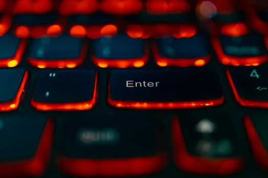 Old laptop with red highlighted keyboard with focus on Enter key