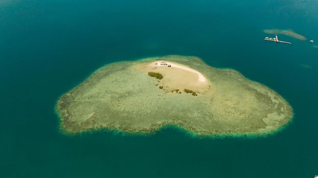 Sandy island with sand bar surrounded by coral reef and blue sea in honda bay, aerial view. Coral atoll with a sandy beach. Summer and travel vacation concept, Philippines, Palawan