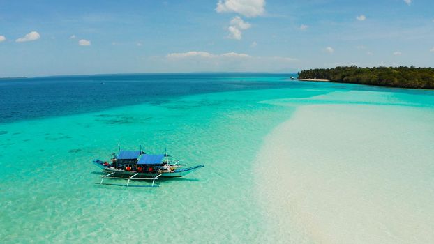 Island with a sandy beach and azure water surrounded by a coral reef and an atoll, aerial view. Mansalangan sandbar, Balabac, Palawan, Philippines. Summer and travel vacation concept
