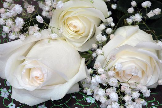 a bouquet of three white roses decorated with flowers for Valentine's day