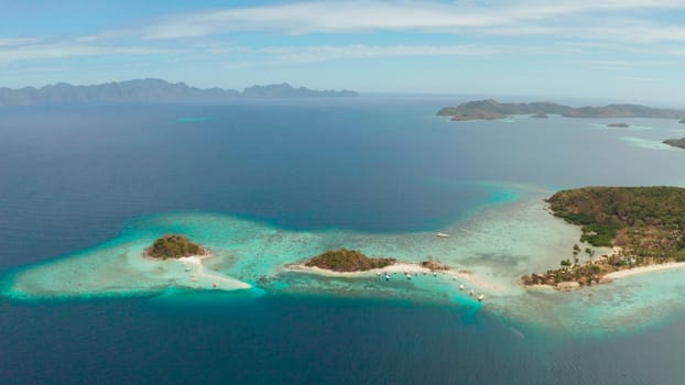 aerial seascape bay with tropical island and sand beach, turquoise water and coral reef. Bulog Dos, Philippines, Palawan. tourist boats on coast tropical island.