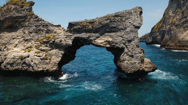Rock in the ocean at Atuh beach on Nusa Penida island, Indonesia. Aerial view of Rocks in a blue sea lagoon with breaking waves. Travel concept.
