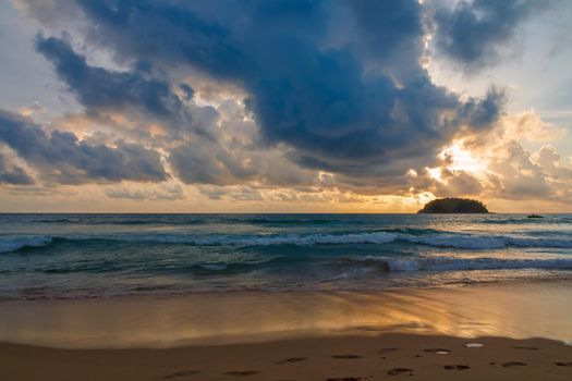 The most gentle sunset on the beautiful sea, the orange sun sparkles with its last rays. On the wet sand, the reflection of the sky and the delightful clouds spreads.