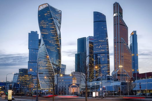 Russia Moscow-City 16.03.2020 International Business Center. Evening time, reflection of lights in the river. Buildings made of glass.