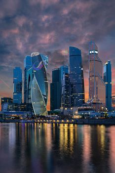 Russia Moscow-City 24.08.2019 International Business Center. Evening time, reflection of lights in the river. Buildings made of glass.