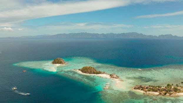 aerial seascape island with white beach. Bulog Dos, Philippines, Palawan. tourist boats on coast tropical island. Seascape bay with turquoise water and coral reef.
