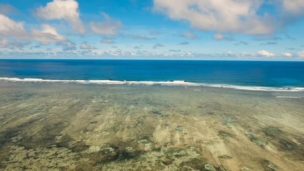 Flying over the blue sea in the azure lagoon. Aerial view: water surface. Tropical sea. Philippines. Flying over the azure surface of the ocean.