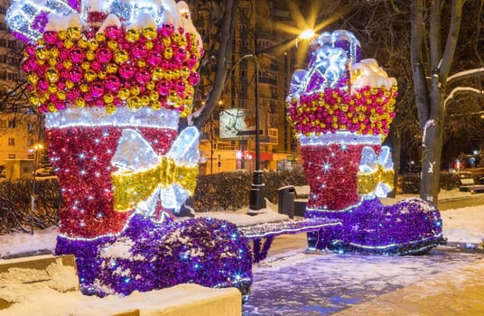 New Year's illumination of the city at dusk. Decorative trees, arches, pavilions in garlands.