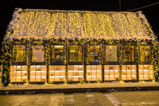 New Year's illumination of the city at dusk. Decorative trees, arches, pavilions in garlands.