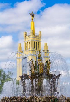 Russia Moscow 12.05.2016 Stone Flower fountain at vdnh In the background is a tall building with a star. Russian architecture.