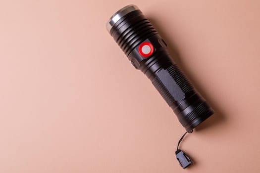 The light for the photographer is durable, powerful, made of aluminum. Flashlight on a pink background