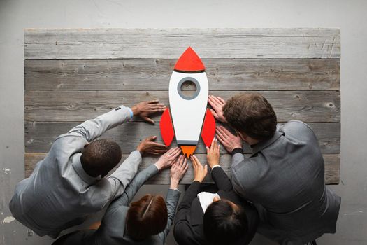 Team of business people with rocket as a sumbol of high risky goals targets success at meeting table