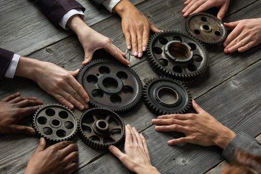 Business people connect gear together at meeting table, success cooperation teamwork concept