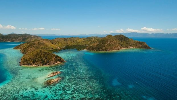 Aerial view: Lagoon with blue, azure water in the middle of small islands and rocks, Palawan. Beach, tropical island, sea bay and lagoon, mountains with forest, Coron. Busuanga. Seascape, tropical landscape. Philippines. Travel concept