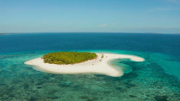 Tropical island with sandy beach by atoll with coral reef and blue sea, aerial view. Patawan island with sandy beach. Summer and travel vacation concept.
