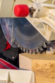 A male worker on the street in winter cuts a block with an angle electric saw with a sharp blade.