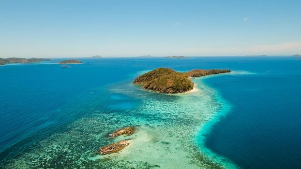 Aerial view: Lagoon with blue, azure water in the middle of small islands and rocks, Palawan. Beach, tropical island, sea bay and lagoon, mountains with forest, Coron. Busuanga. Seascape, tropical landscape. Philippines. Travel concept