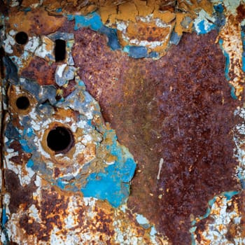 Rust, steel, background. Peeling off old paint Blue yellow white
