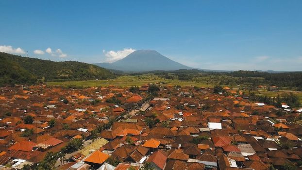 Aerial view Town near volcano Agung, rice terrace, farmlands, village, fields with crops, agricultural land of farmers. Bali, Indonesia