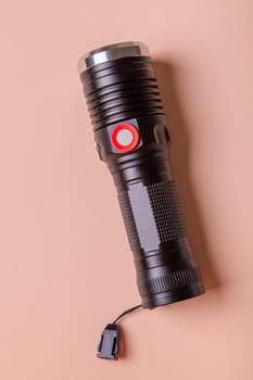The light for the photographer is durable, powerful, made of aluminum. Flashlight on a pink background