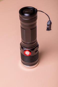The light for the photographer is durable, powerful, made of aluminum. Flashlight on a pink background