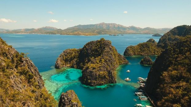 Tropical lagoon with azure water, beach by the Kayangan Lake, Philippines. Aerial view Coron island, with cove, bay at Kayangan lake. Lagoon with sailing boats. Aerial video. Philippines. Travel concept