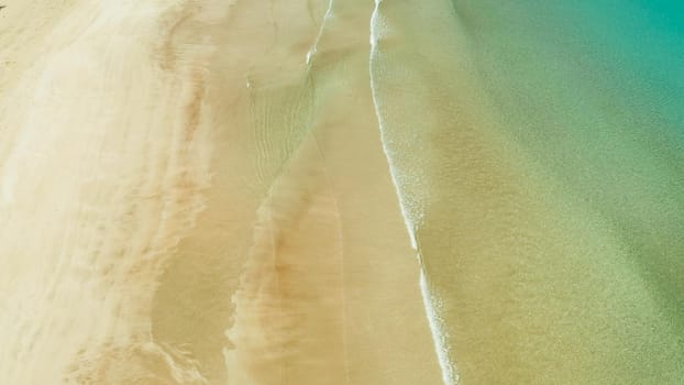 aerial view Tropical sandy beach and sea with clear water,space for text. Ocean with waves and yellow beach. Summer and travel vacation concept