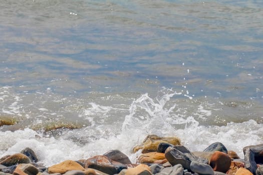 pebbles and stones on the beach. waves and splashes on the shore. High quality photo