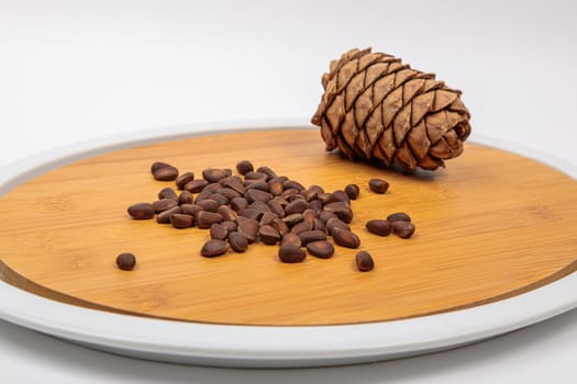 The fruit of Siberian cones - pine nuts on a kitchen cutting board, is a delicious, nutritious and healthy product.