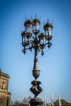 Luxurious antique street lamp made of black metal. Refined style, forging.